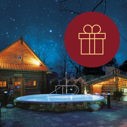 Ein runder Pool aus Stein. Im Hintergrund zwei Saunahütten. Darüber ein dunkelblauer Sternenhimmel